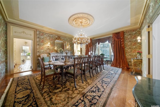 dining room featuring hardwood / wood-style floors, an inviting chandelier, and crown molding