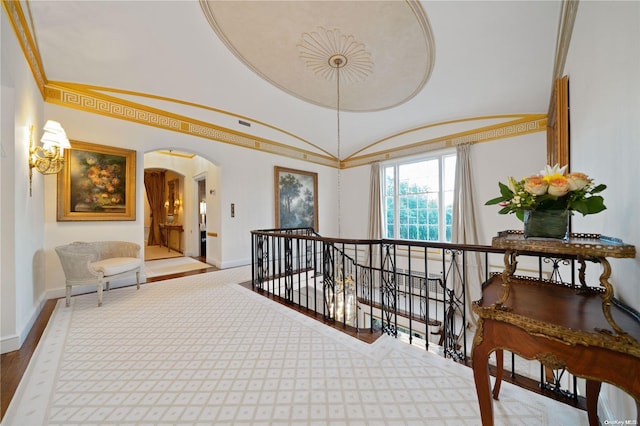 hall with vaulted ceiling and ornamental molding