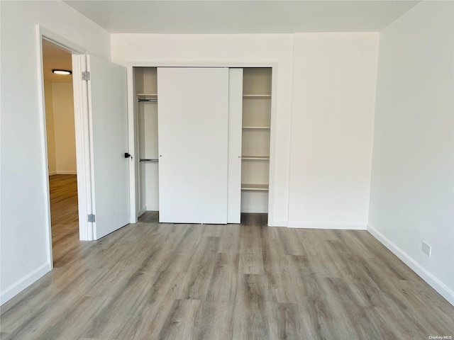 unfurnished bedroom featuring light hardwood / wood-style floors and a closet