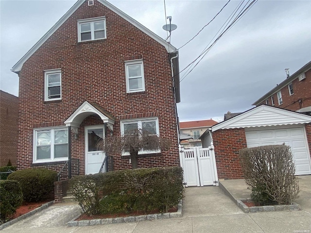 traditional-style home featuring concrete driveway, brick siding, and a gate