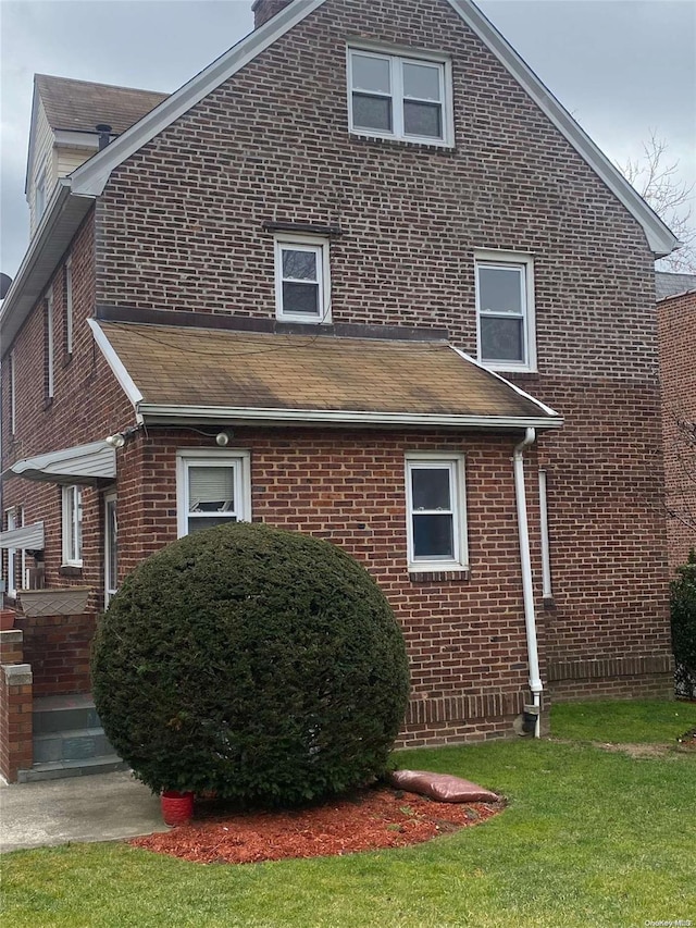 view of home's exterior featuring brick siding and a yard