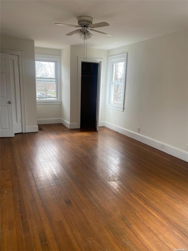 unfurnished bedroom with a ceiling fan, dark wood finished floors, and baseboards