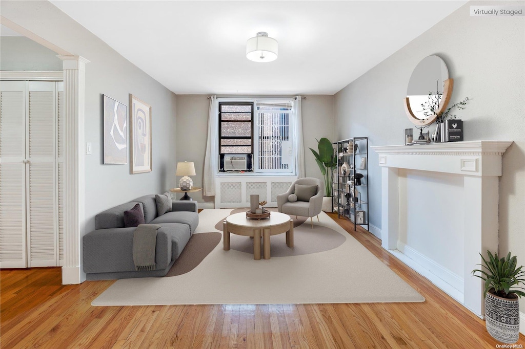 living room featuring radiator, hardwood / wood-style floors, and cooling unit