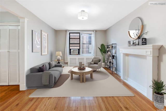 living room featuring radiator, hardwood / wood-style floors, and cooling unit