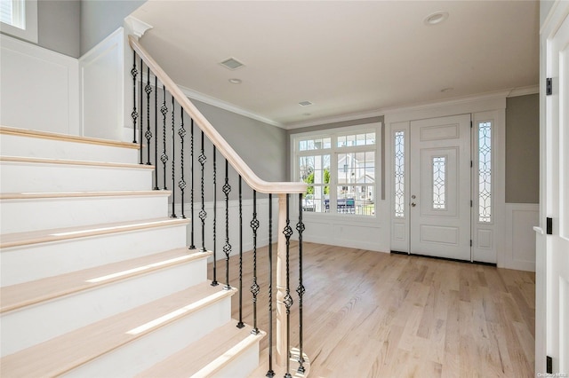 entrance foyer featuring light hardwood / wood-style flooring and ornamental molding