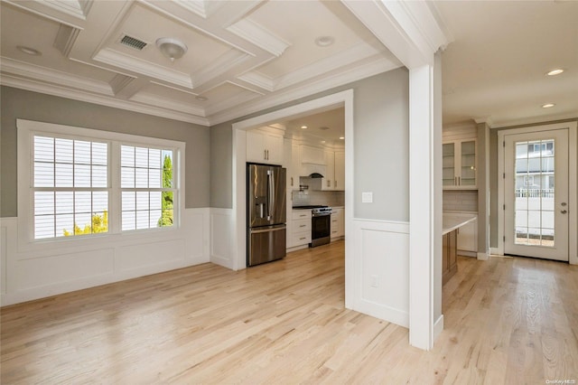 kitchen with backsplash, light hardwood / wood-style flooring, ornamental molding, appliances with stainless steel finishes, and white cabinetry