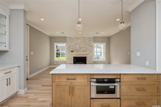 kitchen with crown molding, stainless steel oven, and hanging light fixtures