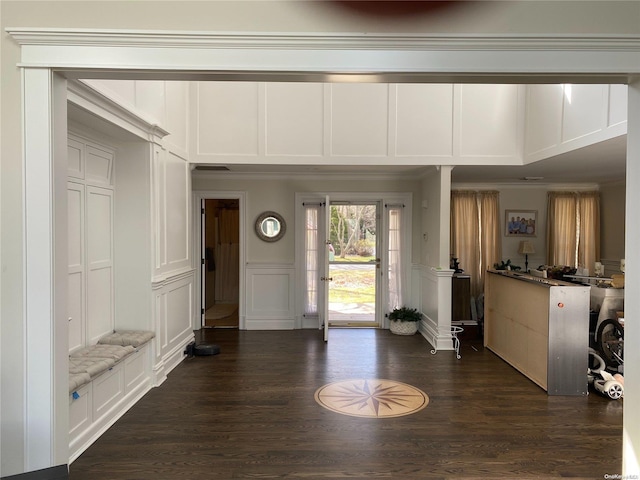 foyer with ornamental molding and dark wood-type flooring