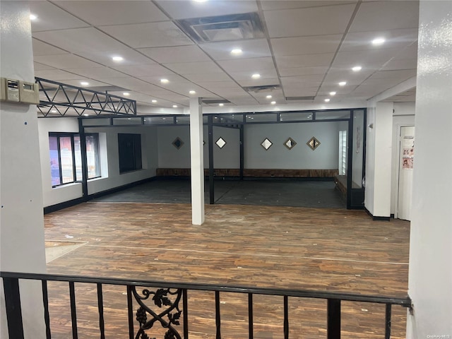 interior space featuring a drop ceiling and dark hardwood / wood-style flooring