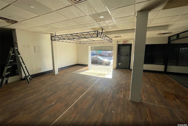 interior space featuring a drop ceiling and dark hardwood / wood-style floors