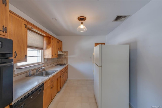 kitchen featuring pendant lighting, sink, backsplash, and black appliances