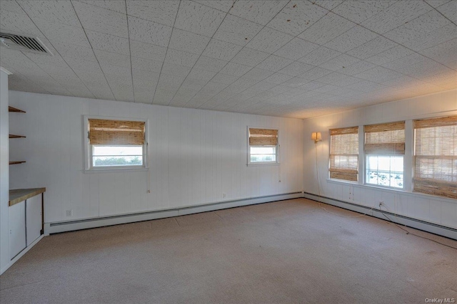 unfurnished room with a healthy amount of sunlight and a baseboard heating unit