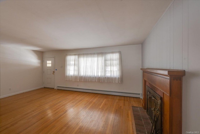 unfurnished living room featuring a baseboard radiator and light wood-type flooring