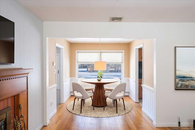 dining area with a baseboard radiator and light hardwood / wood-style floors