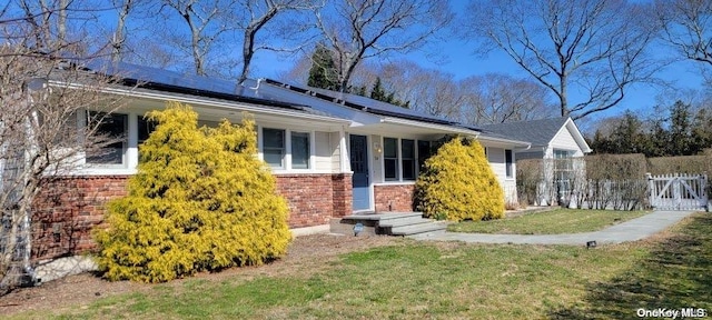 ranch-style house with a front yard and solar panels