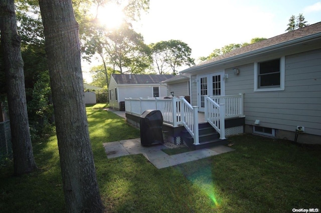 rear view of house featuring a lawn and a wooden deck