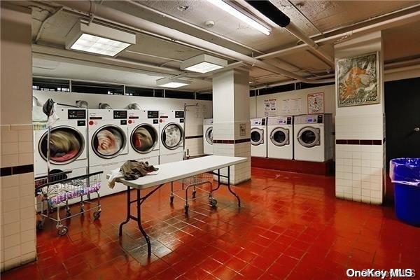 washroom with tile walls and washing machine and clothes dryer