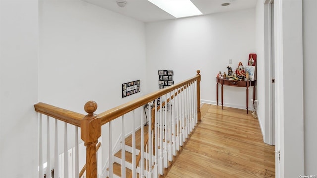 hall featuring light wood-type flooring and a skylight