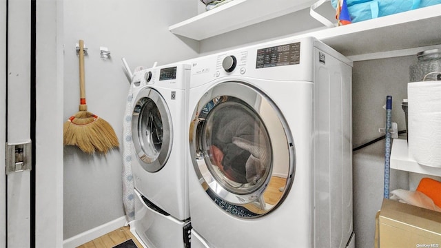 clothes washing area featuring separate washer and dryer and light hardwood / wood-style flooring