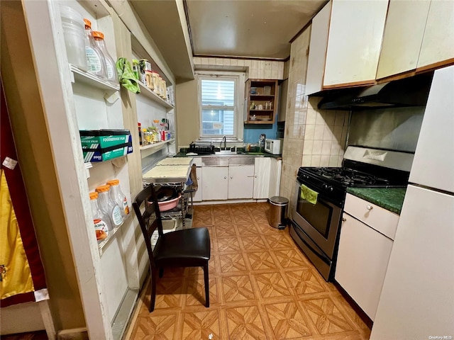 kitchen with backsplash, white appliances, white cabinetry, and sink