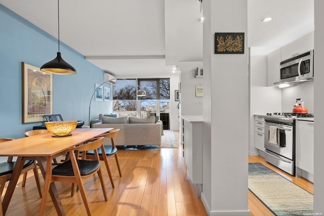 dining area featuring light wood-type flooring and a wall mounted AC