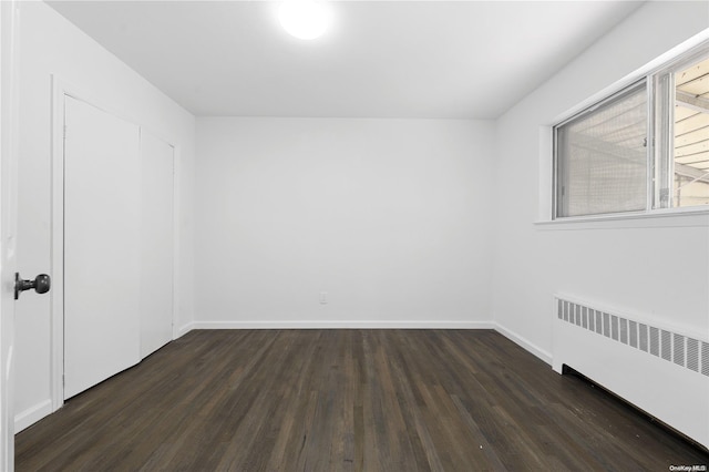 unfurnished room featuring dark hardwood / wood-style floors and radiator