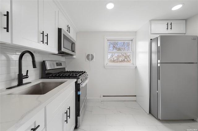 kitchen featuring sink, light stone countertops, a baseboard radiator, white cabinetry, and stainless steel appliances