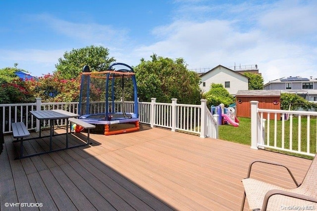 wooden terrace featuring a playground and a trampoline