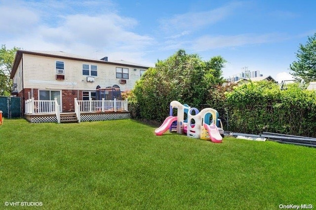 back of house featuring a yard, a playground, and a wooden deck