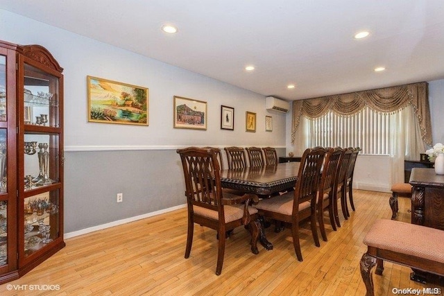 dining space with light wood-type flooring and a wall mounted AC