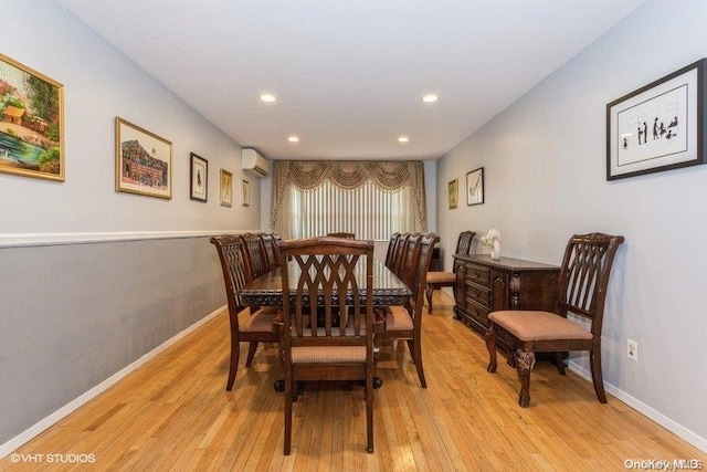 dining space featuring a wall mounted AC and light hardwood / wood-style floors