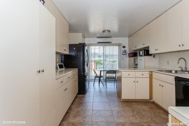 kitchen featuring a wall mounted air conditioner, sink, black appliances, light tile patterned floors, and white cabinetry