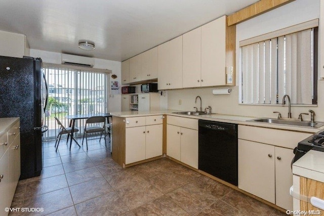 kitchen with black appliances, white cabinets, an AC wall unit, and sink