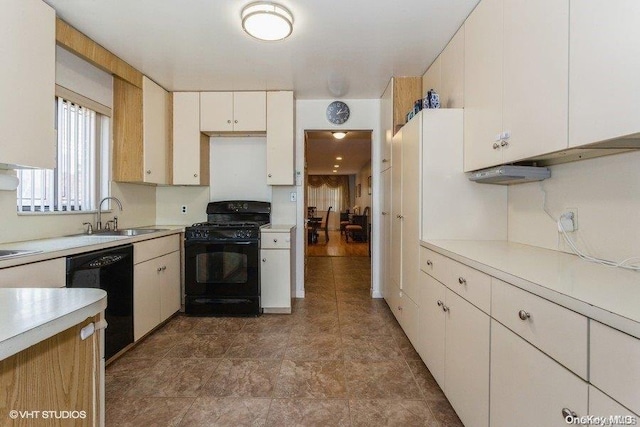 kitchen with white cabinetry, sink, and black appliances