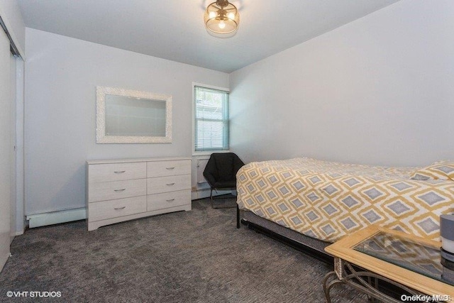 bedroom featuring dark carpet, baseboard heating, and a closet