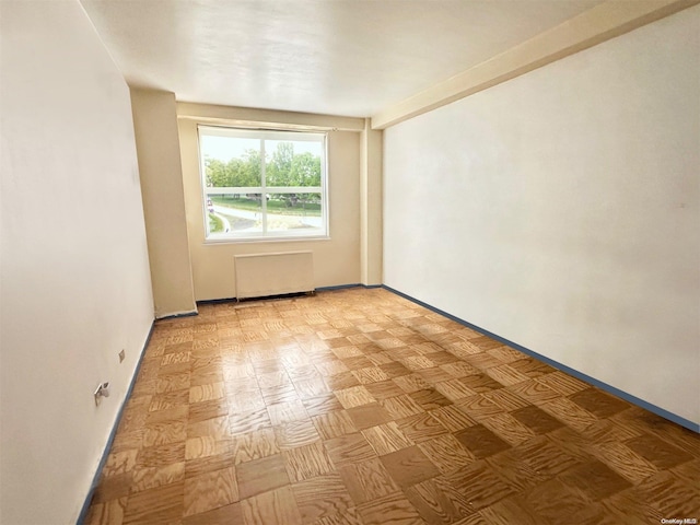 unfurnished room featuring radiator heating unit