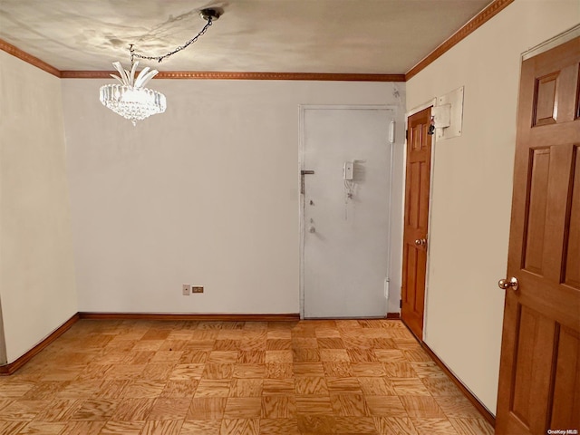 spare room featuring light parquet flooring, ornamental molding, and an inviting chandelier