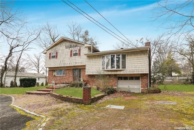 split level home featuring a garage and a front lawn