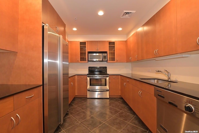 kitchen featuring dark tile patterned floors, sink, and appliances with stainless steel finishes