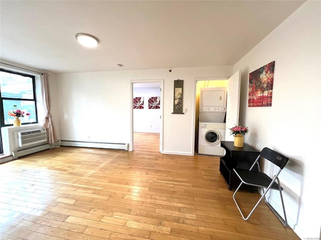 interior space featuring a baseboard radiator, light hardwood / wood-style floors, an AC wall unit, and stacked washer / drying machine