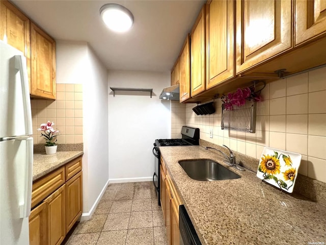 kitchen with gas stove, sink, range hood, white fridge, and decorative backsplash