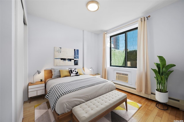 bedroom featuring an AC wall unit and light hardwood / wood-style flooring