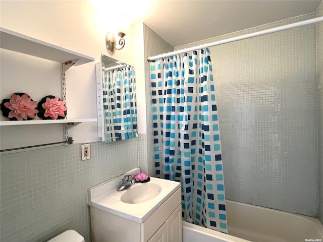 full bathroom featuring shower / bath combo, vanity, toilet, and tile walls