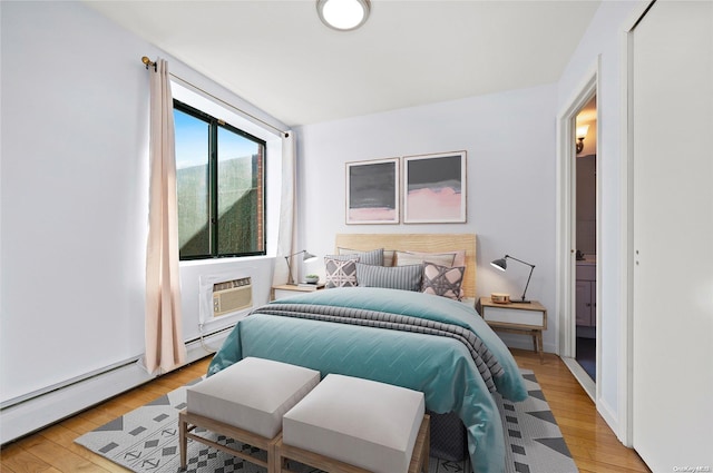 bedroom featuring an AC wall unit and light hardwood / wood-style flooring