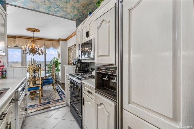 kitchen with white cabinets, ornamental molding, black range with gas cooktop, light tile patterned floors, and a chandelier