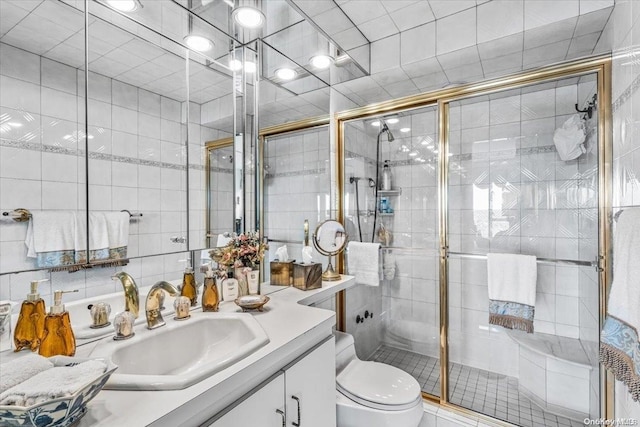 bathroom featuring vanity, a shower with shower door, and tile walls