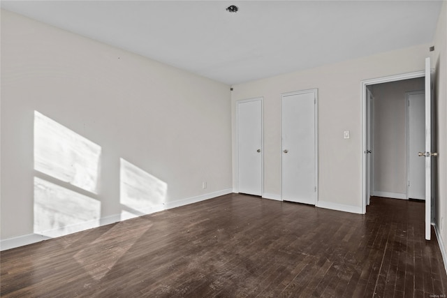 unfurnished bedroom with dark hardwood / wood-style flooring