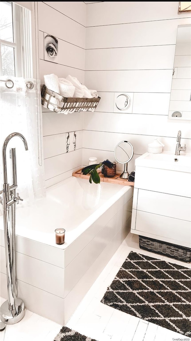 bathroom with tiled bath and vanity