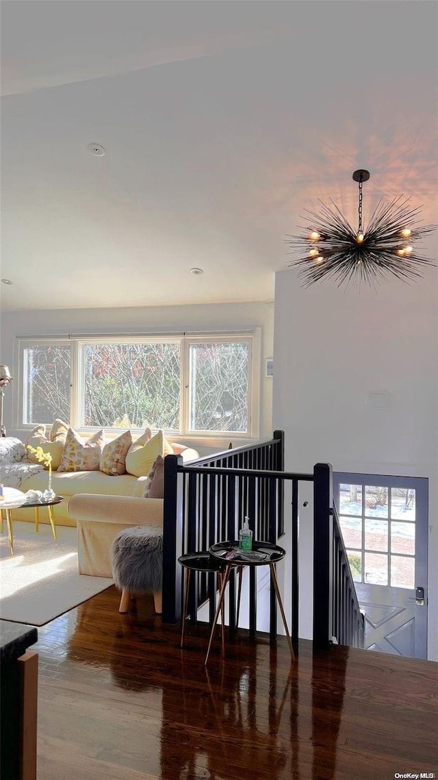 interior space with a healthy amount of sunlight, dark hardwood / wood-style floors, and an inviting chandelier