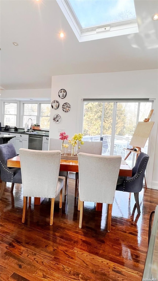 dining area featuring a skylight and wood-type flooring